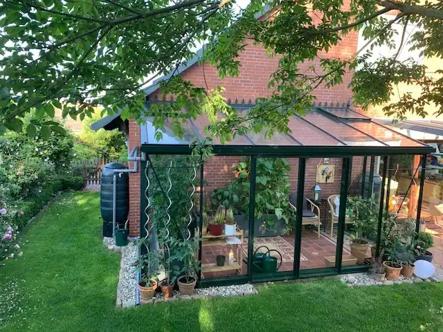 Gewächshaus am Backsteinhaus mit viel Grün, HOGATEK von Hof und Garten Wittstock.